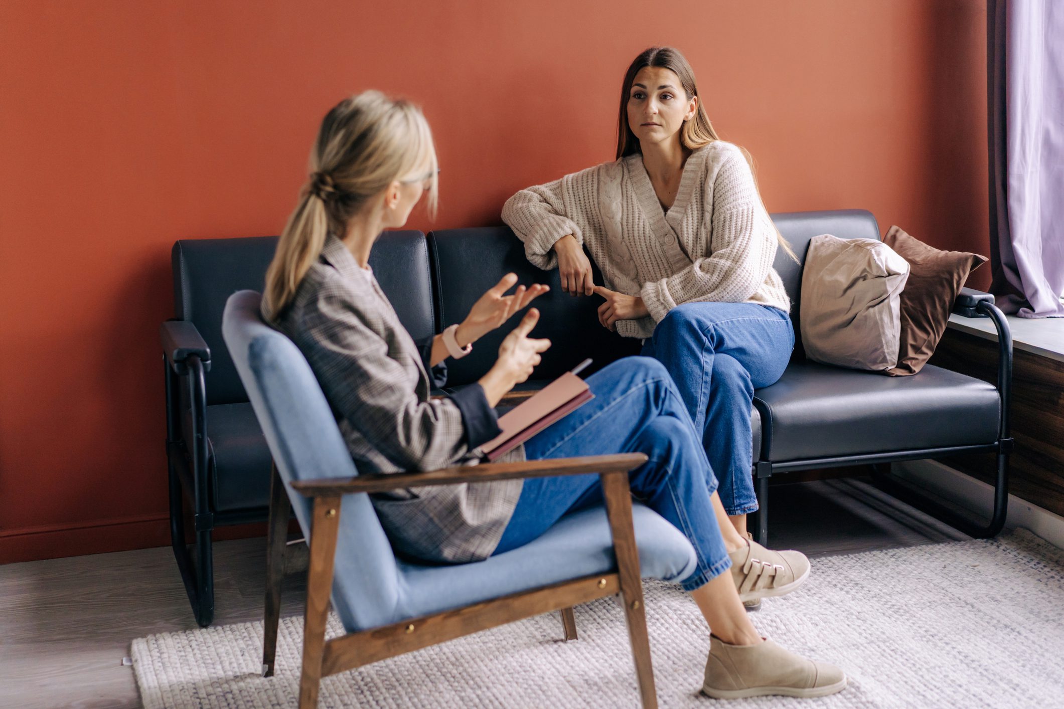 Two women having a serious conversation indoors.